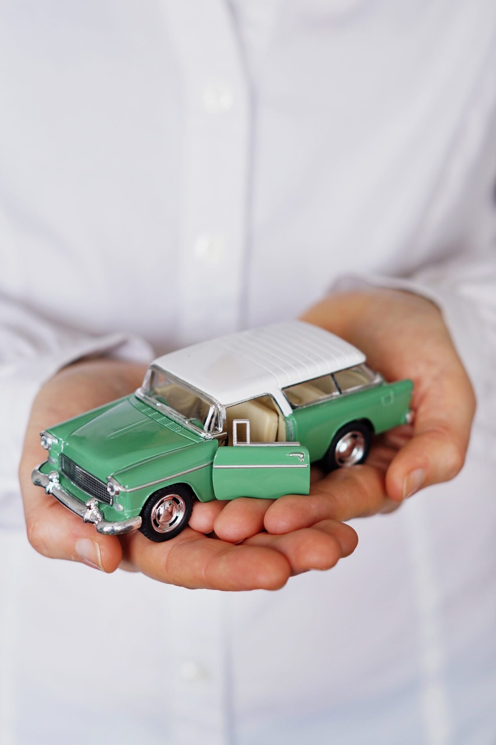 A vertical closeup shot of a person thinking of buying a new car or selling a vehicle